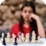 A woman in sitting in front of a chessboard thinking her next move.